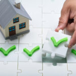 A,Person's,Hand,Solving,Check,Mark,Puzzle,Near,House,Model