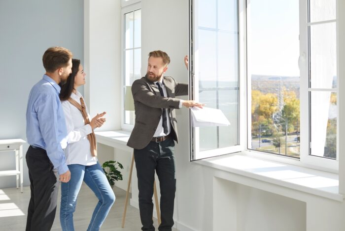 Real estate agent showing new home interior to potential buyers